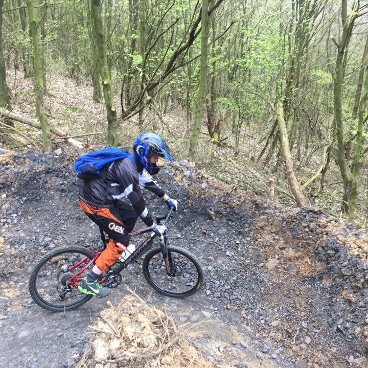 Een mountainbiker maakt een bocht tijdens een afdaling in het bos