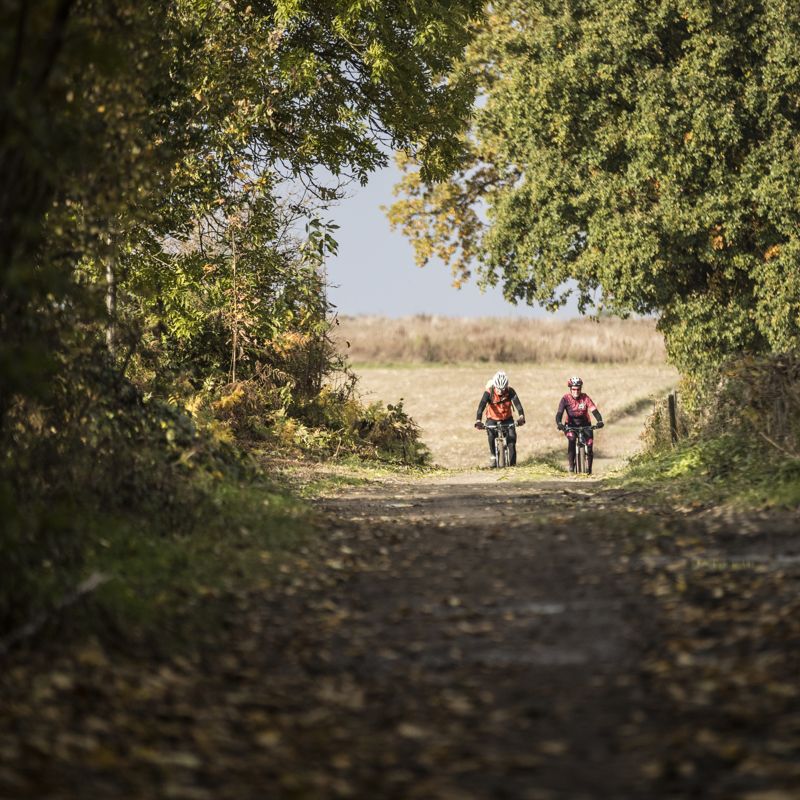 Twee mountainbikers in aantocht over een holle weg