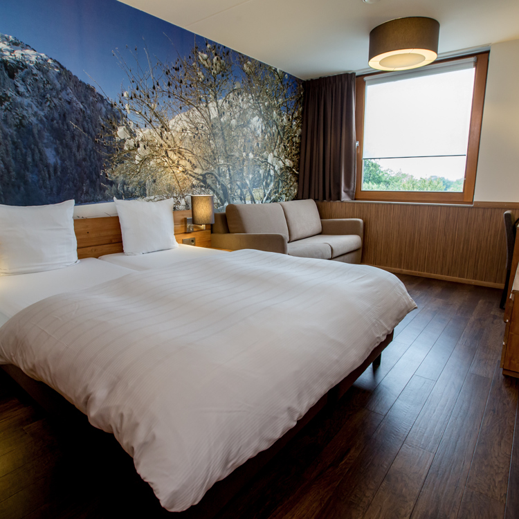 Hotelkamer met houten vloer en houten details in een skihotel. 