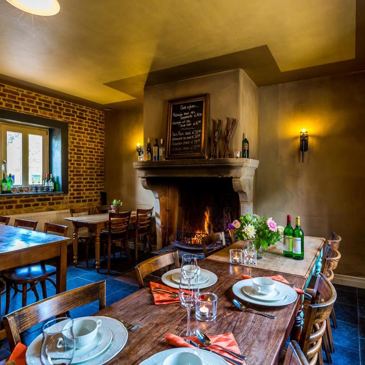 Het interieur en een gedekte tafel bij Ausberge De Smockelar