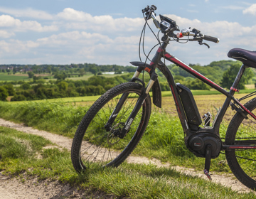 Een rode mountainbike staat geparkeerd in het heuvellandschap 