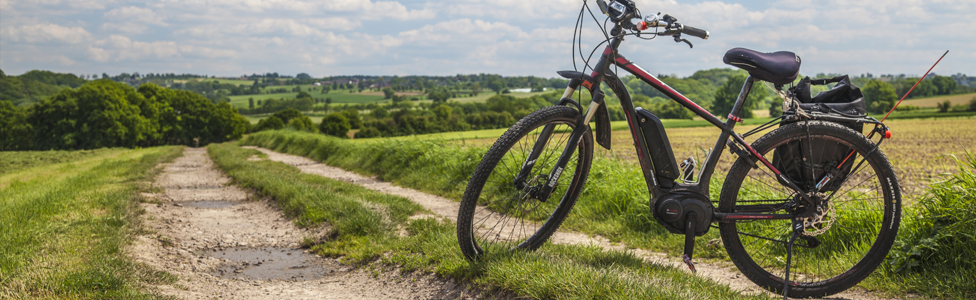 Een rode mountainbike staat geparkeerd in het heuvellandschap 