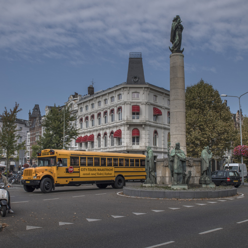 Een bustour in een gele Amerikaanse schoolbus in het centrum van Maastricht