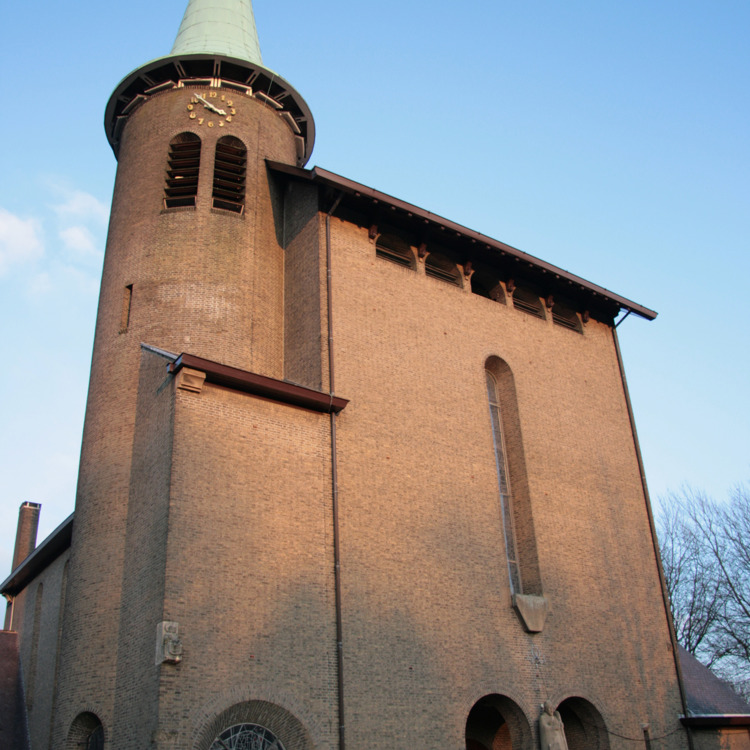 Gevel van de Kunstenaarskerk H. Hubertuskerk in Genhout met ronde glas in lood raam