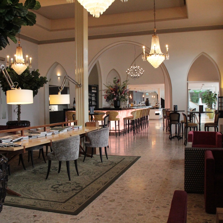 lobby van een luxe hotel met een lange leestafel en bar. 
