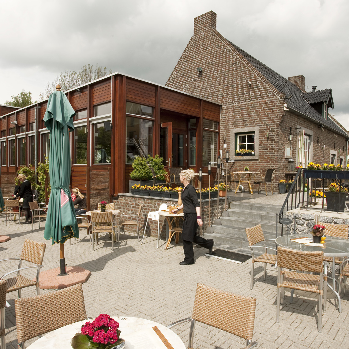 Een serveerster loopt buiten over het terras van Café Restaurant Aan de Meule