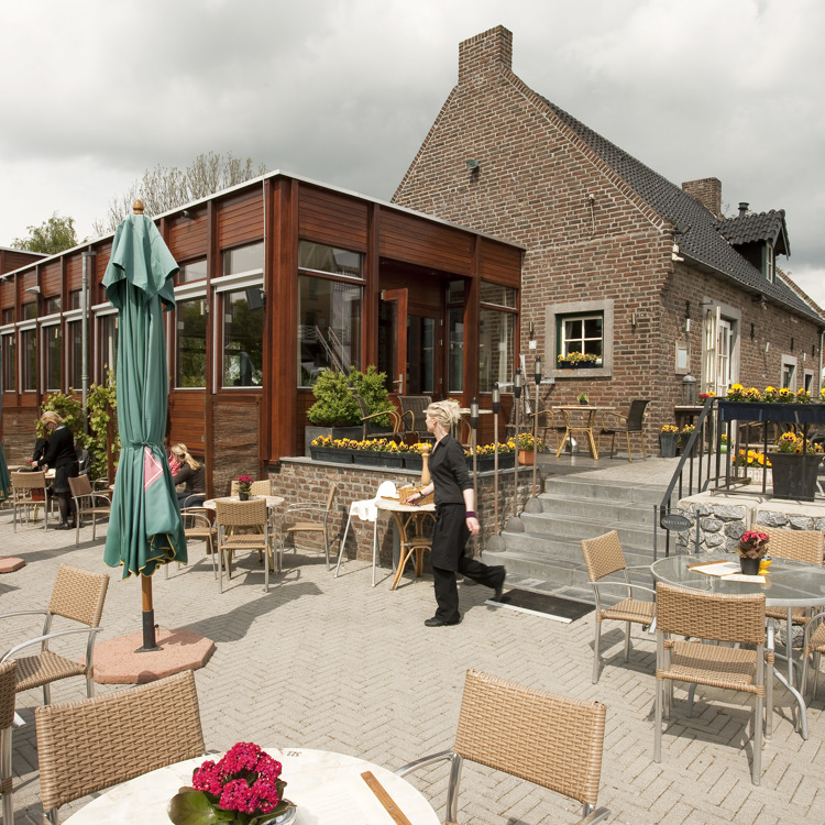 Een serveerster loopt buiten over het terras van Café Restaurant Aan de Meule