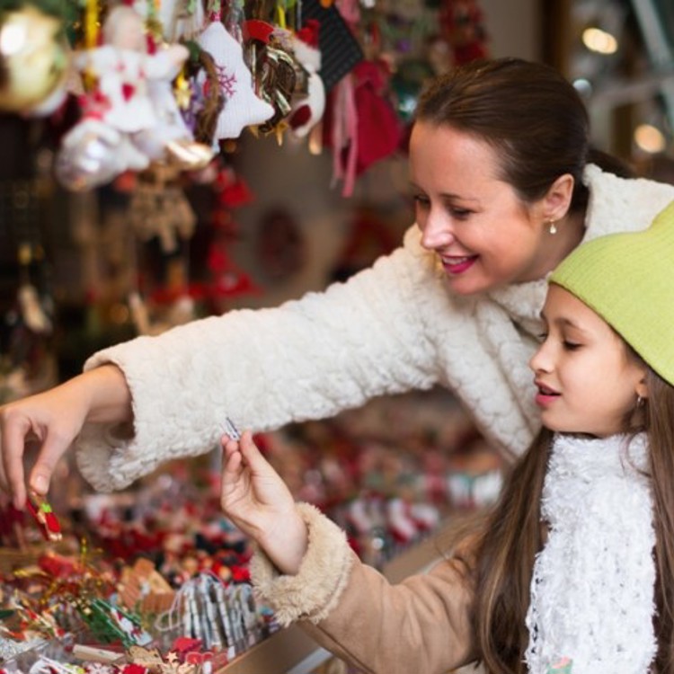 Moeder en dochter bekijken spulletjes bij kerststalletje