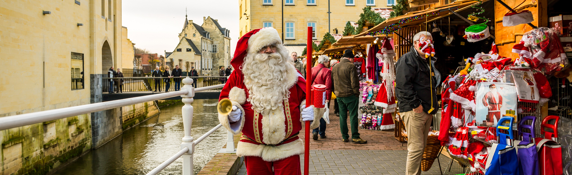 Kerstman loopt langs kerstkraampjes en Geul op Santa's Village