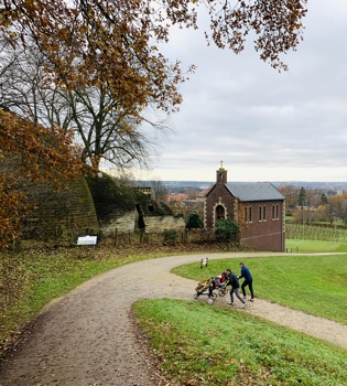 Kapelletje bij Bemelen met een gezin dat de berg ernaast omhoog loopt met de kinderwagen