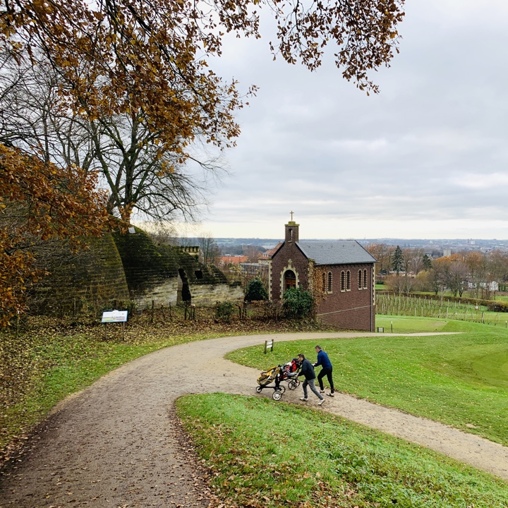 Kapelletje bij Bemelen met een gezin dat de berg ernaast omhoog loopt met de kinderwagen