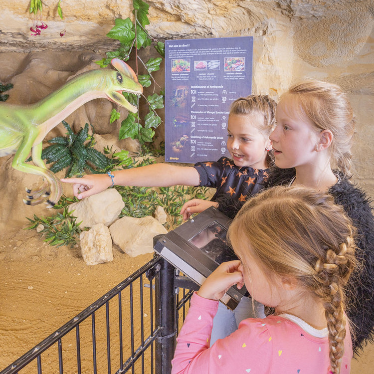 Drie kinderen bij een dinosaurus in MergelRijk Valkenburg