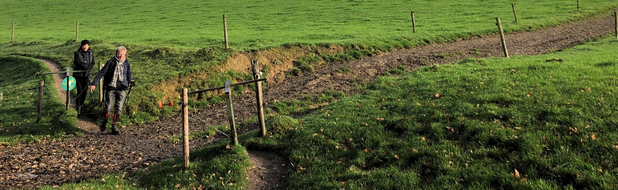 Twee vrouwen wandelen door de heuvels en passeren twee draaihekjes