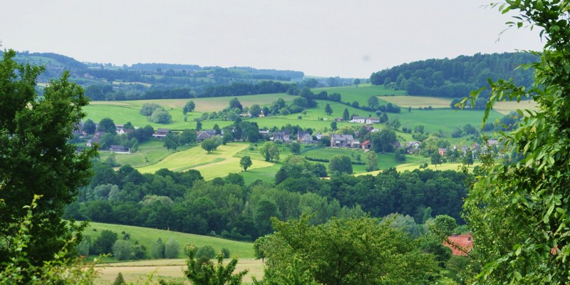 Een mooi uitzicht vanaf een wandelpad over een dorp en het groene landschap 