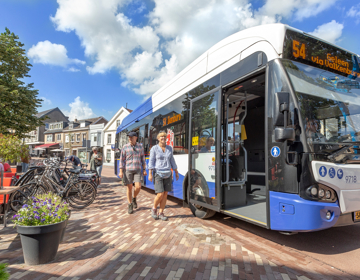 Opstappende mensen bij een bus in Gulpen markt