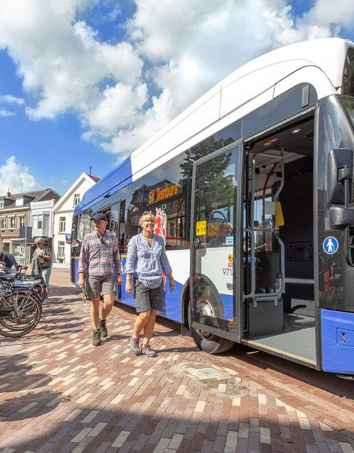 Opstappende mensen bij een bus in Gulpen markt