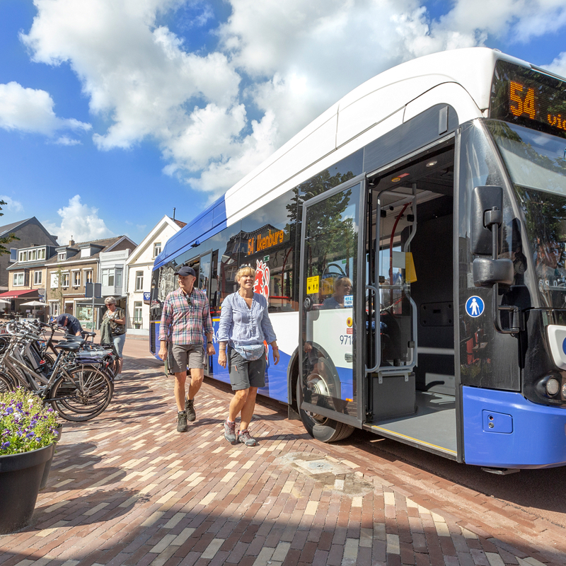 Twee wandelaars lopen langs een Arriva bus in Gulpen