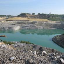 Helderblauw water in een groeve omringd door steen.