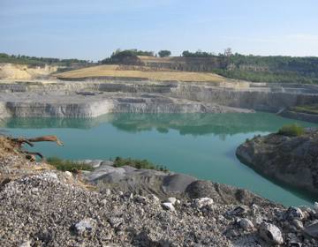 Helderblauw water in een groeve omringd door steen.