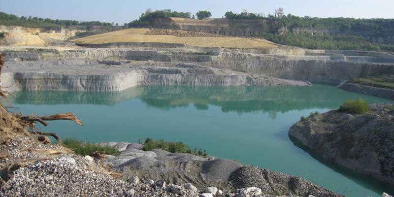 Helderblauw water in een groeve omringd door steen.