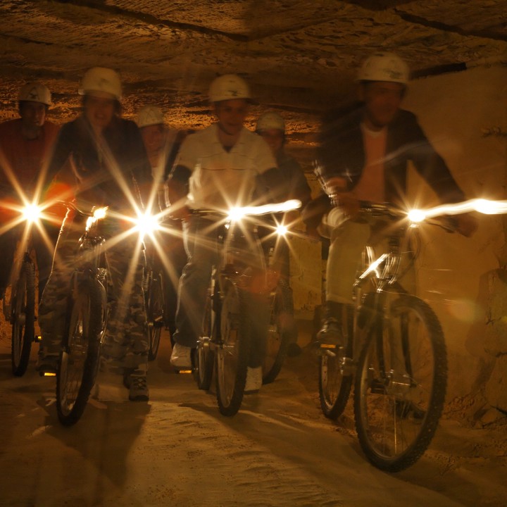 een groep is aan het grotbiken in de groeves van Valkenburg. 