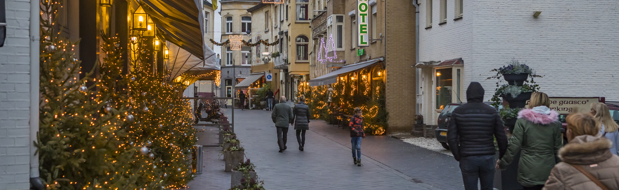 Mensen lopen door kerst versierde straten in Valkenburg