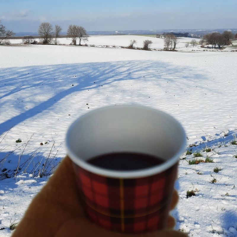 Koffie to go tijdens het winterwandelen in een besneeuwd landschap