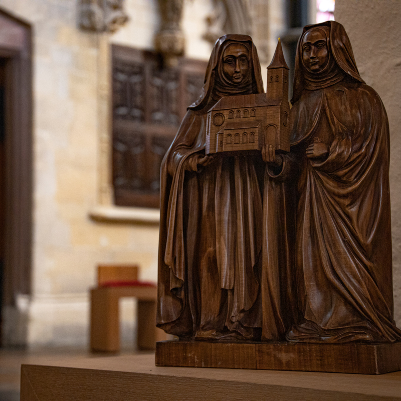 Beeld van twee mensen die een kerk dragen