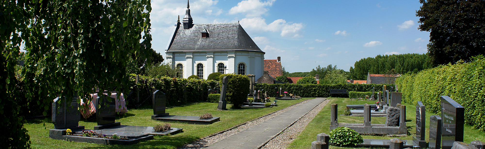 Buitenaanzicht en begraafplaats van het protestantse kerkje in urmond