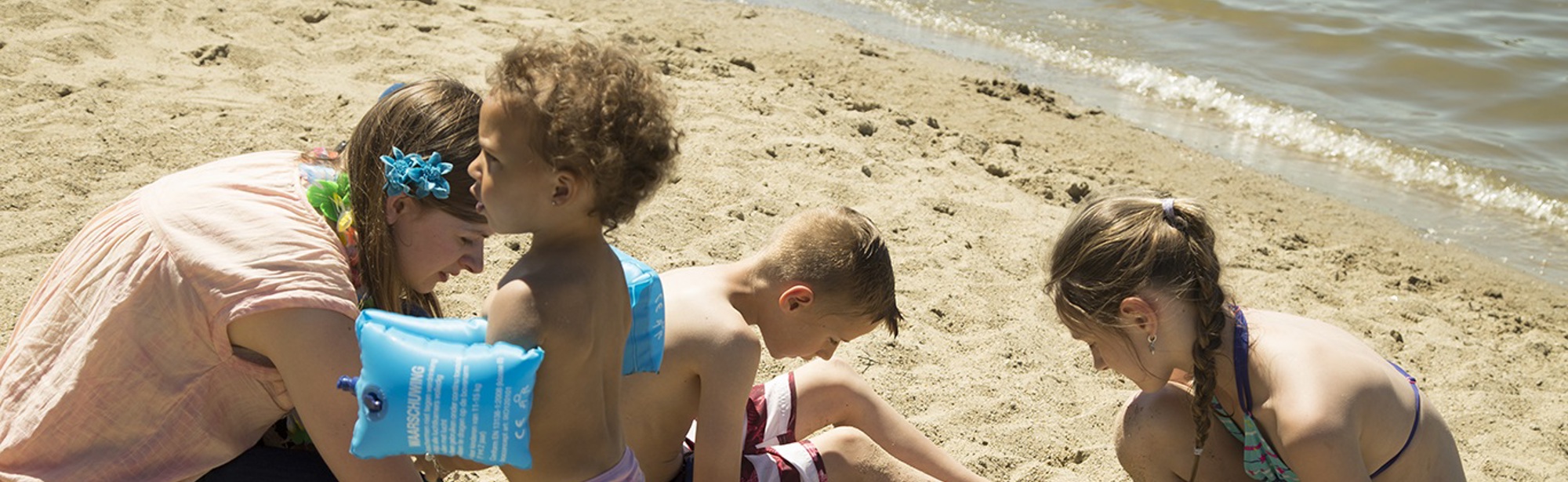 Kinderen spelen met zand op het strand bij FunValley