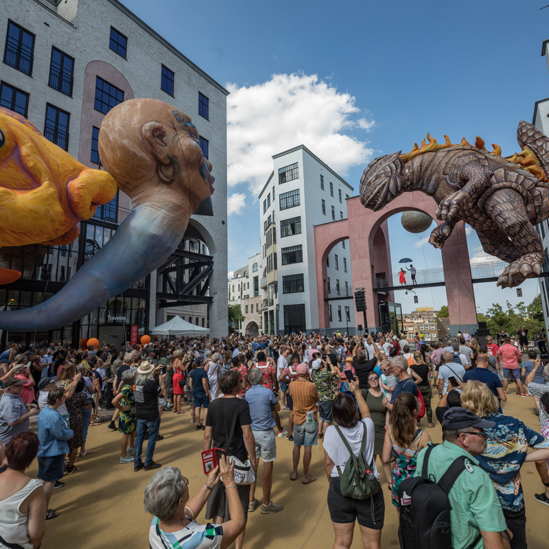 Een groot publiek kijkt naar de Cultura Nova Parade bij het Maankwartier in Heerlen