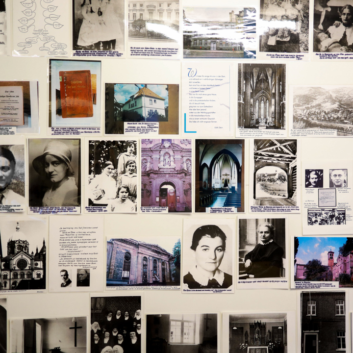 Verschillende foto's en oude krantenartikelen van Edith Stein aan de muur