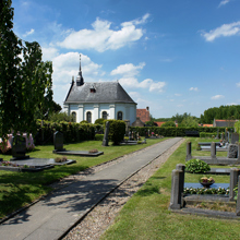 Een pad over een kerkhof dat uitkomt bij een wit protestants kerkje