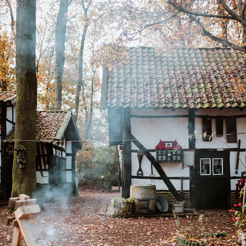 Een vuurtje brandt tijdens de herfst met de op achtergrond twee vakwerkhuisjes