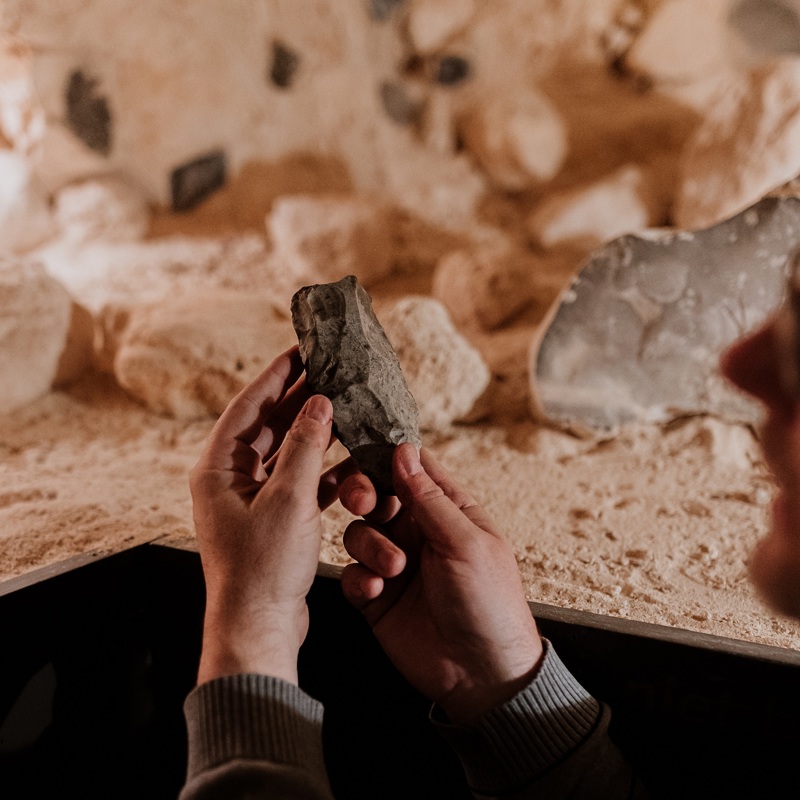 Joep Orbons houdt een ondergronds prehistorisch gesteente vast met zijn handen