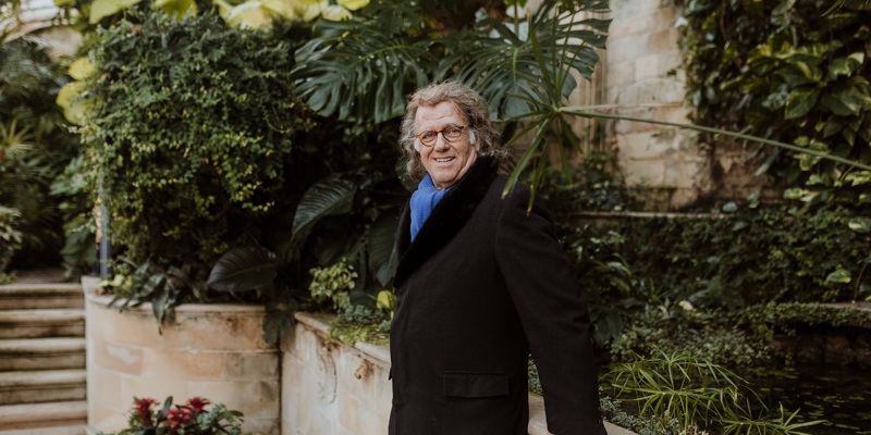 André Rieu poseert in een tuin met veel planten