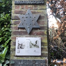 Plaquette en joodse ster in alluminium op een stenen zuil 