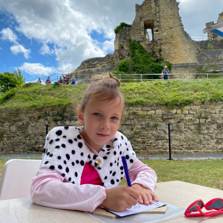 Meisje verkleed als prinses met zwarte/witte bontkraag tekent voor kasteelruïne Valkenburg