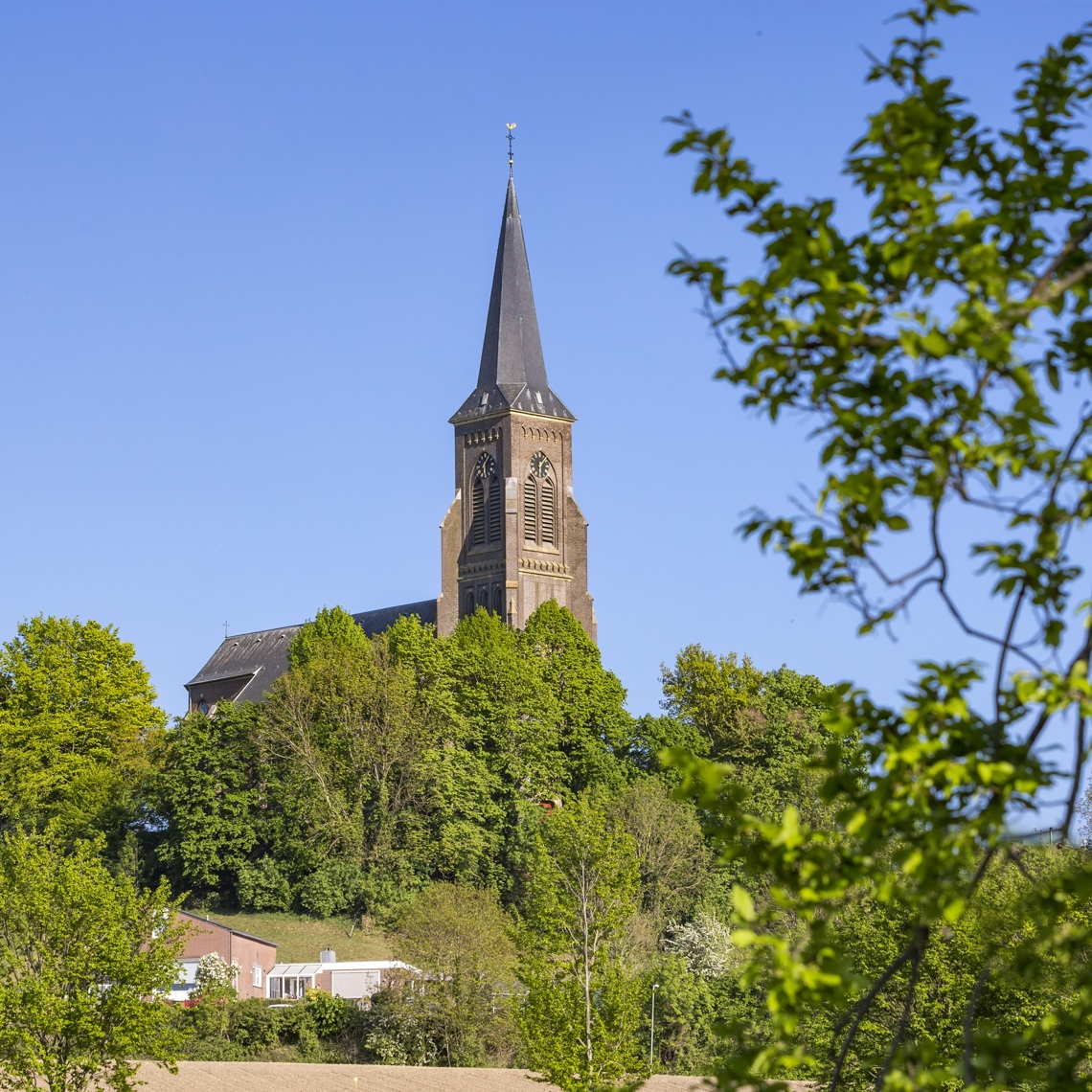 De kerk van Vijlen die boven de groene natuur pronkt