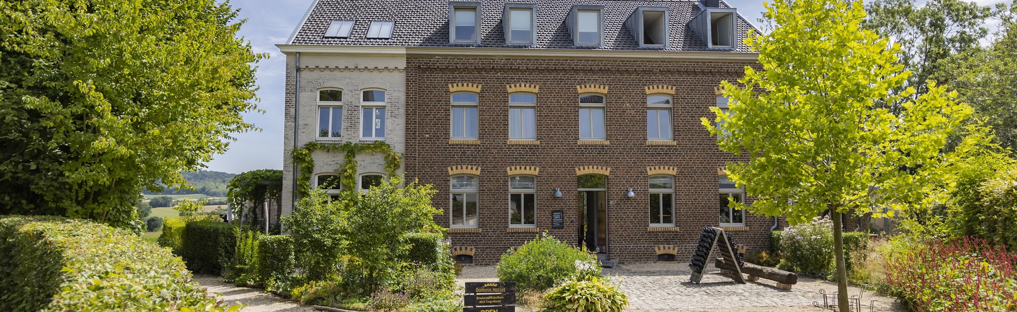 De accommodatie van Domein Holset met voortuin op een zomerse dag