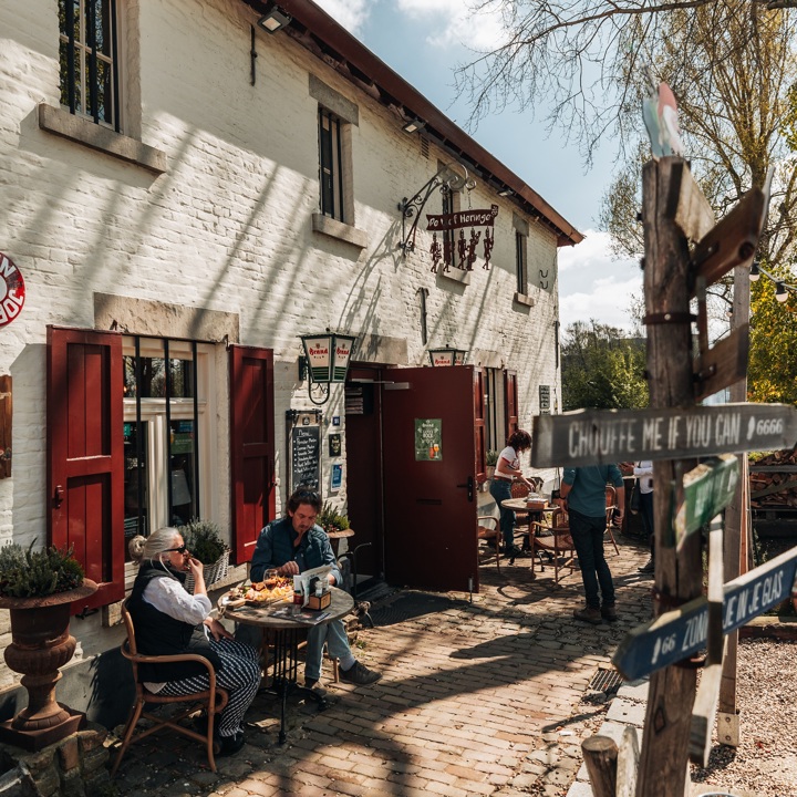 Mensen genieten van een lunch aan een tafeltje op het terras van de Vief Heringe 