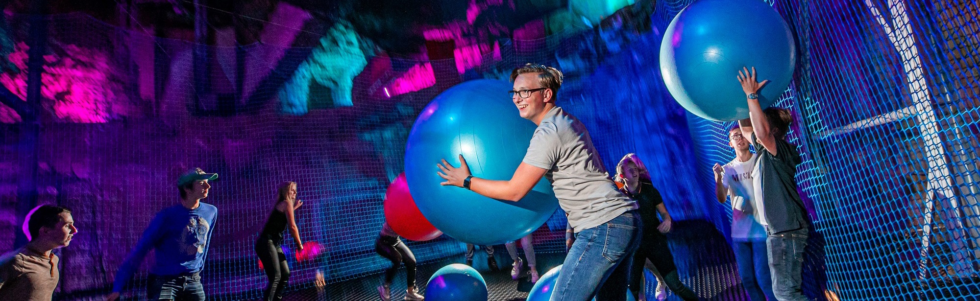 Kinderen hebben plezier met grote bounceballen op netten