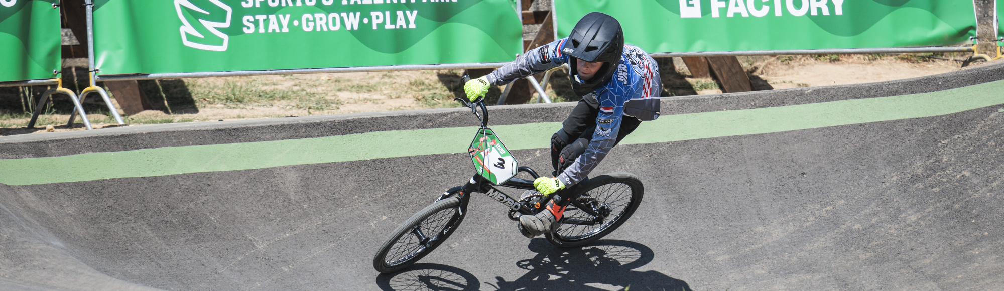 Jongen met helm op BMX op Pumptrack