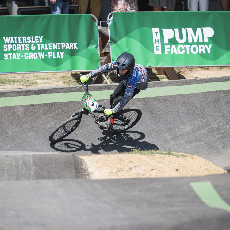 Jongen met helm op BMX op Pumptrack