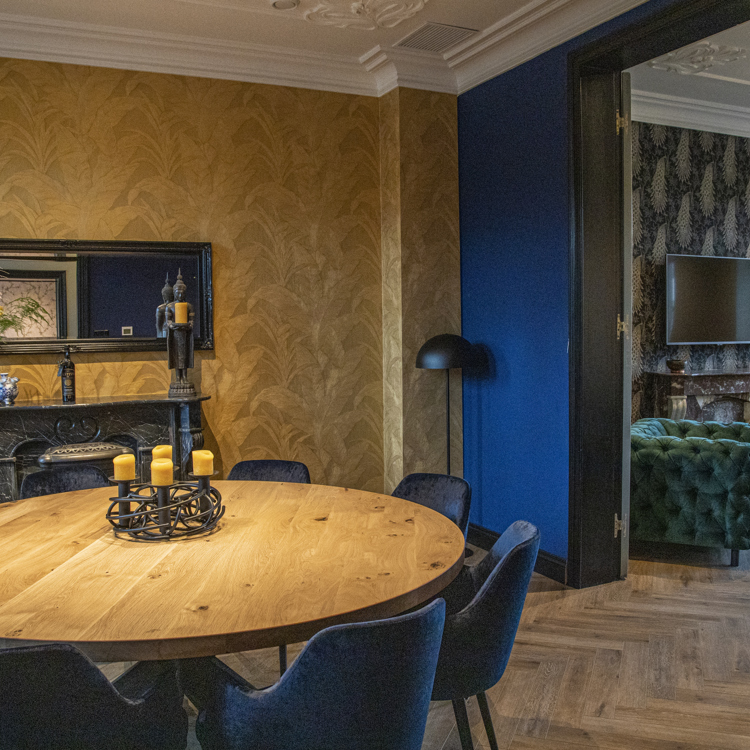 Eetkamer van sfeervolle B&B met hout, goud en blauwe details. 