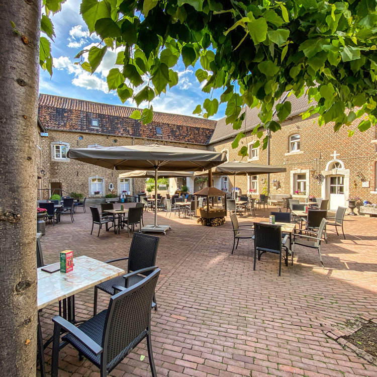 Lege terrastafeltjes op de binnenhof van een oude boerderij