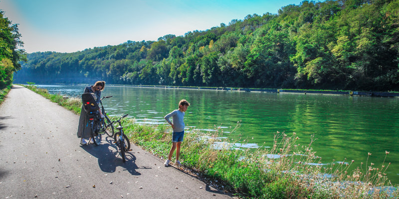 Gezin pauzeert met fietsen langs het kanaal 