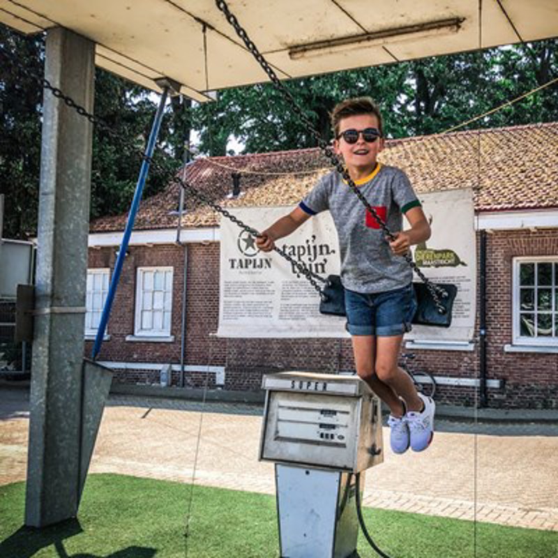 Jongetje op een schommel bij de tapijnkazerne 