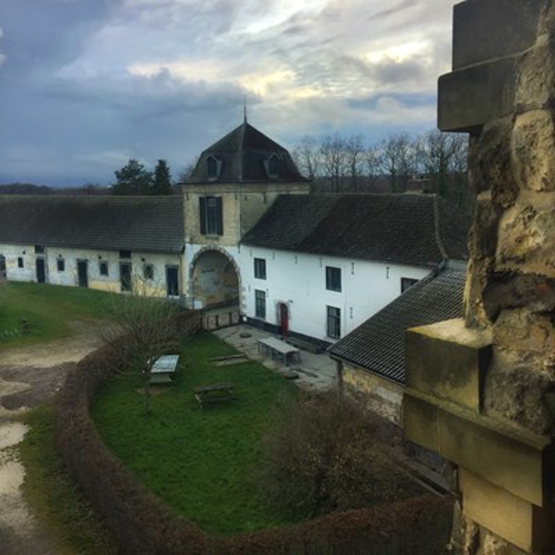 Oud monumentaal pand met een grote ronde poort. 