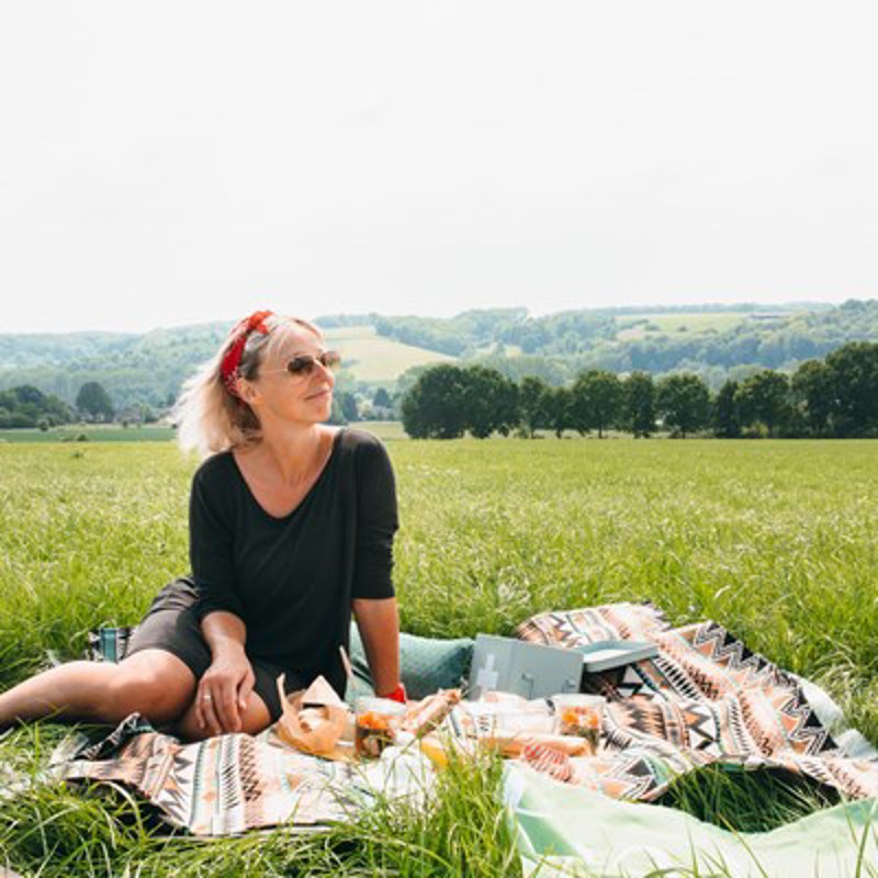 Josje op een picknickkleed met uitzicht op het heuvelland